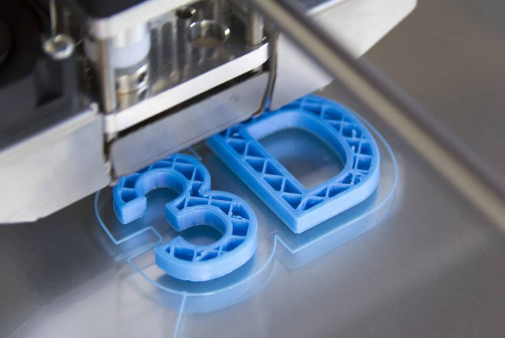 Das Bild zeigt die Buchstaben 3 und D, wie sie als plastischer Gegenstand mit einem 3D-Drucker gedruckt werden.