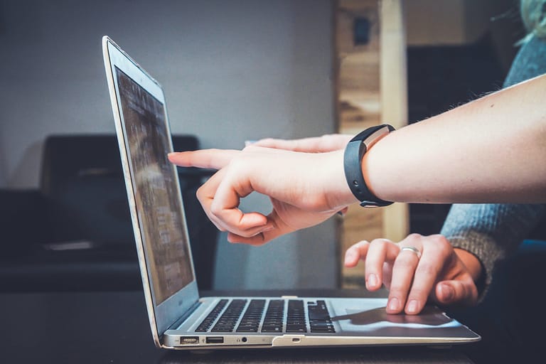 Menschen arbeiten zusammen an einem Laptop