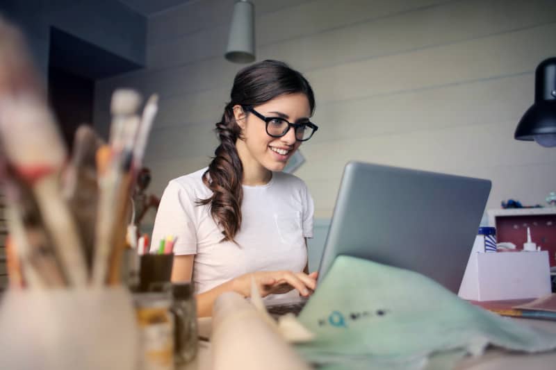 Eine Frau sitzt zufrieden vor Ihrem benutzerfreundlichen Laptop